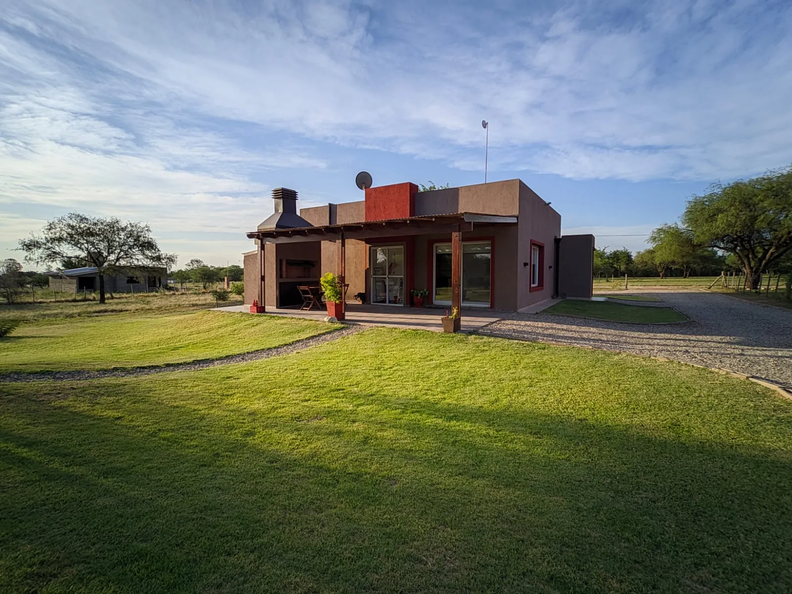 Cabaña Cerro de Jah con galería y parque, iluminada por el sol de la mañana