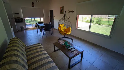 Living con sillón, mesa de madera y silla colgante